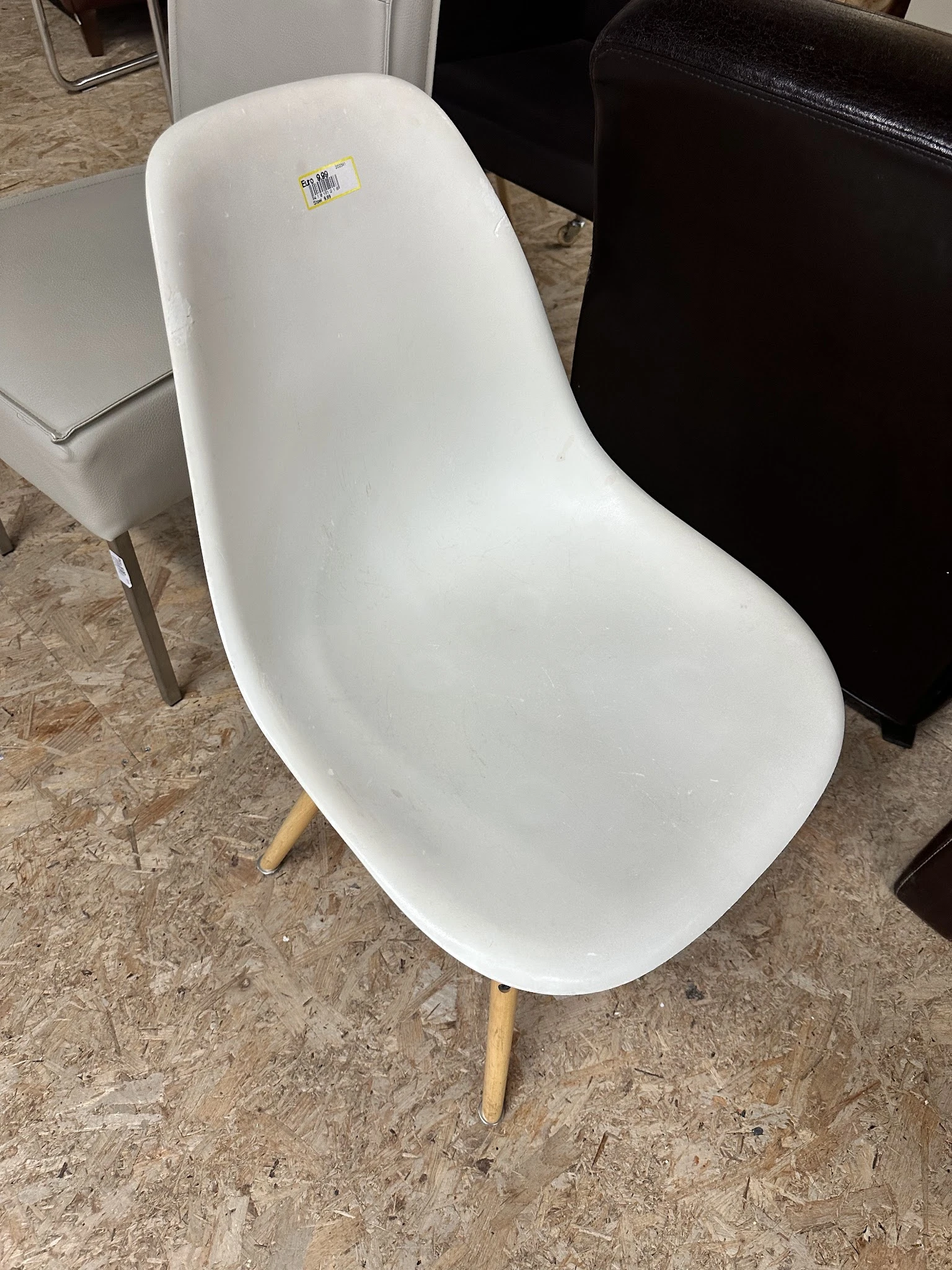 Witte moderne stoel met voetensteun op houten vloer