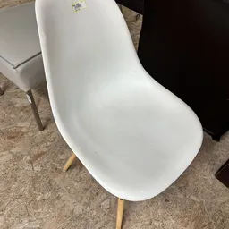Witte moderne stoel met voetensteun op houten vloer