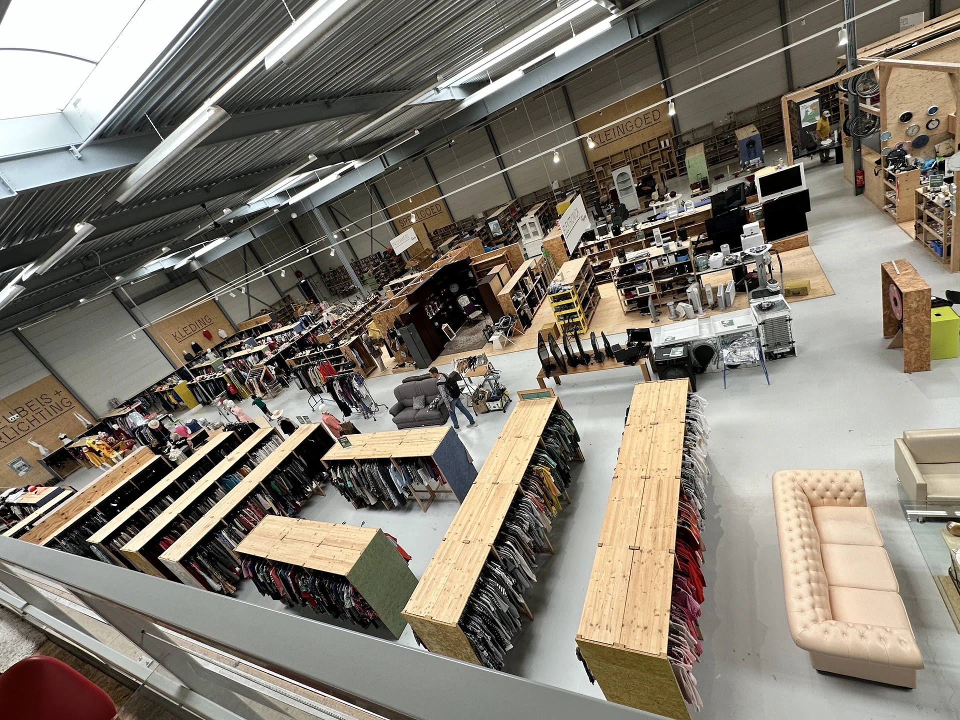 Overzicht van de winkelvloer met uitgestalde meubels, waaronder banken, houten tafels en stoelen.