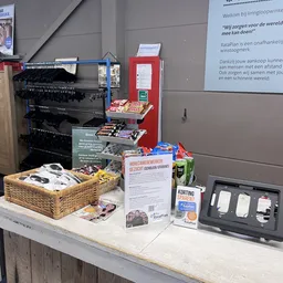 Tafel met tweedehands spullen: manden, dvd's, VHS-tapes, boeken en accessoires
