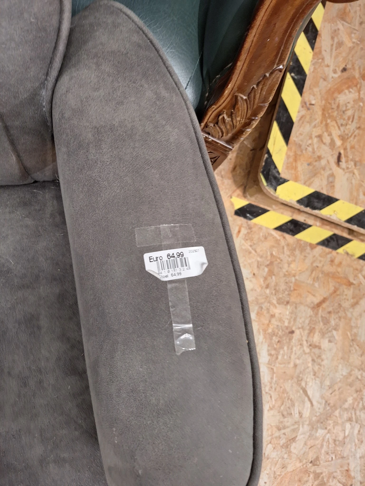 Close-up van een grijze stof of kledingstuk met prijssticker €47,64,99