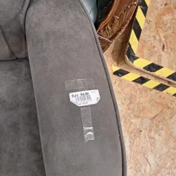 Close-up van een grijze stof of kledingstuk met prijssticker €47,64,99