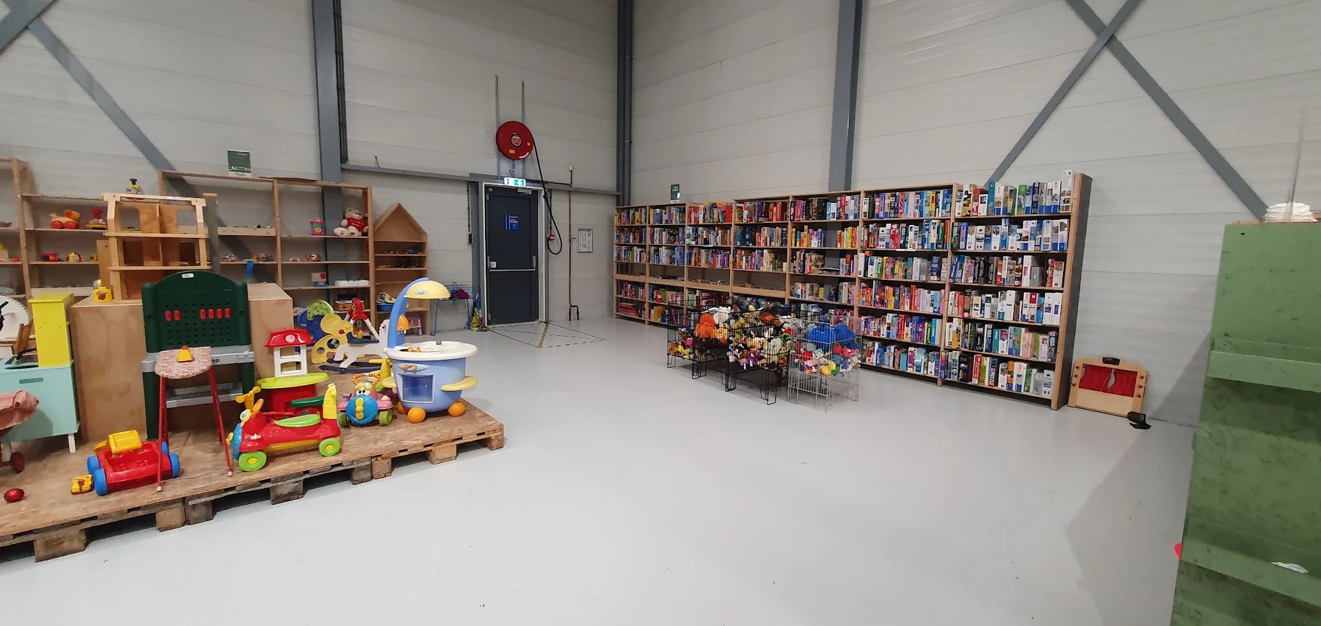 Ruim winkelbinnenland met speelgoed links, boekenrekken rechts en decoratie in het midden