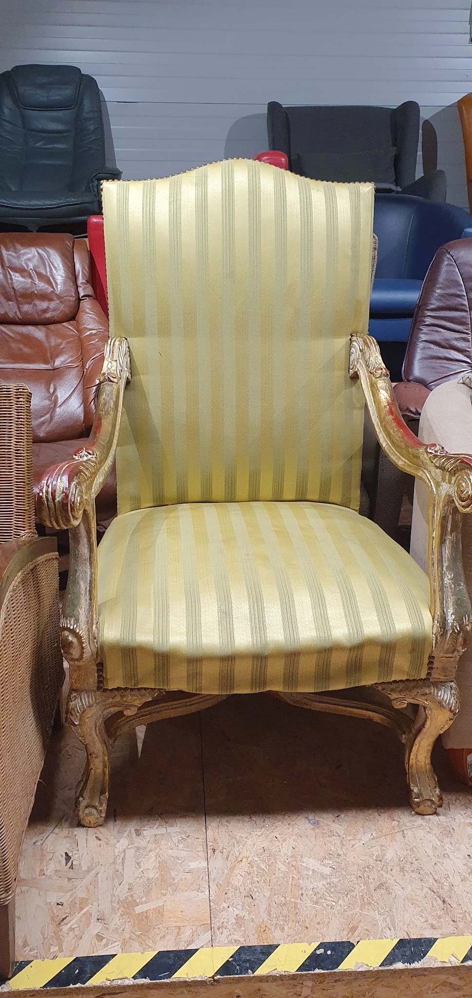 Goudkleurige fauteuil met groen gestreepte bekleding, close-up van zitting en rugleuning