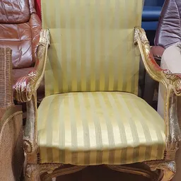 Goudkleurige fauteuil met groen gestreepte bekleding, close-up van zitting en rugleuning