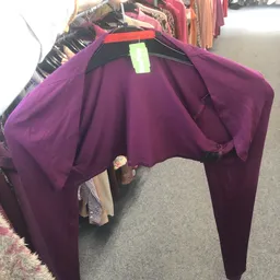 Paarse jurk op kleerhanger tegen zwarte achtergrond