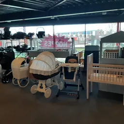 Kinderwagens, babyboxen en babymeubilair uitgestald in de kringloopwinkel