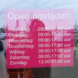 Roze bord met openingstijden van een winkel