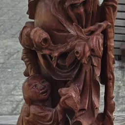 Houten sculptuur met ornamentale details en gezichten, kunsthandwerk