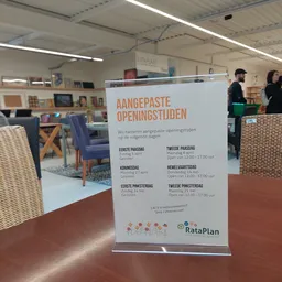 Informatiebord met openingstijden en details over aangepasten openingstijden van de winkel