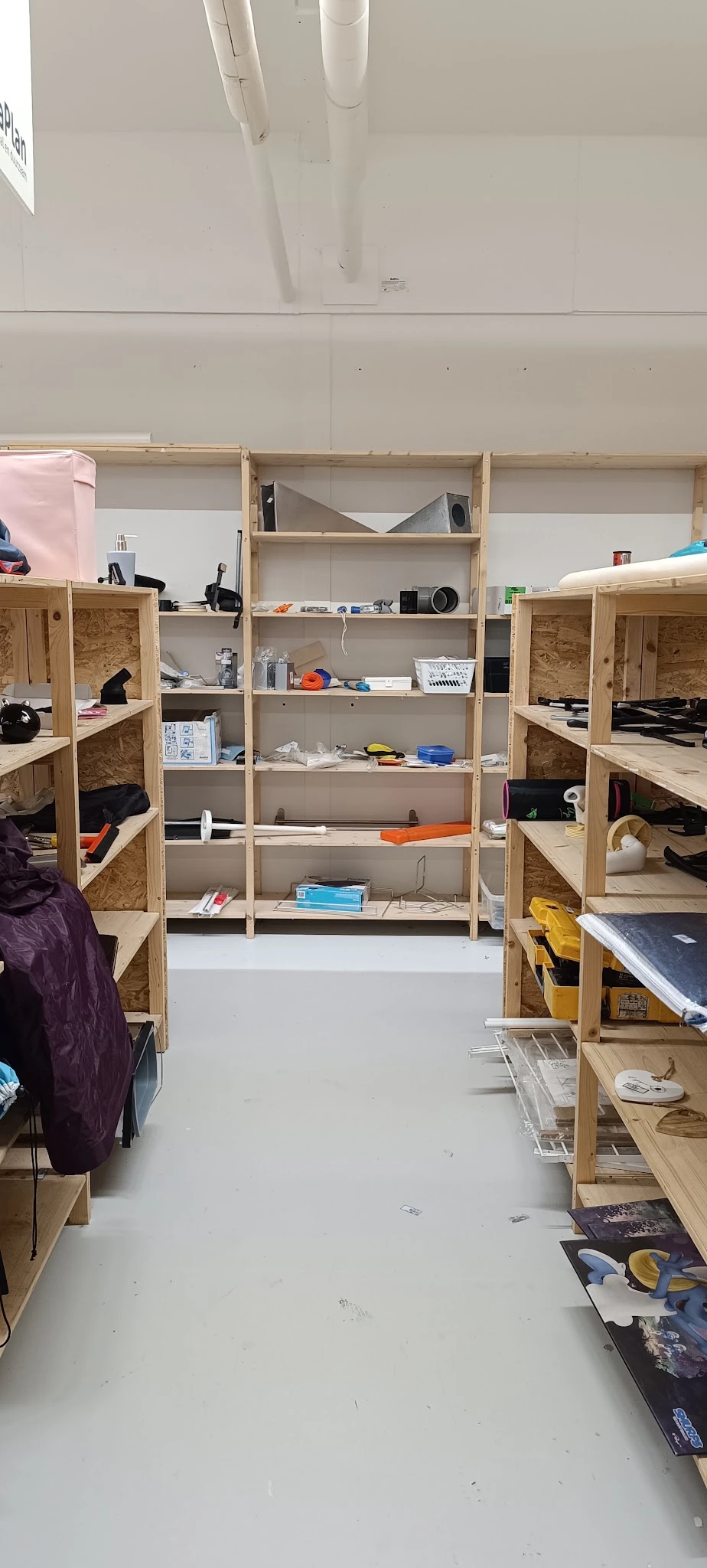 Houten stellingen met diverse artikelen en dozen in een kringloopwinkel