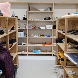 Houten stellingen met diverse artikelen en dozen in een kringloopwinkel