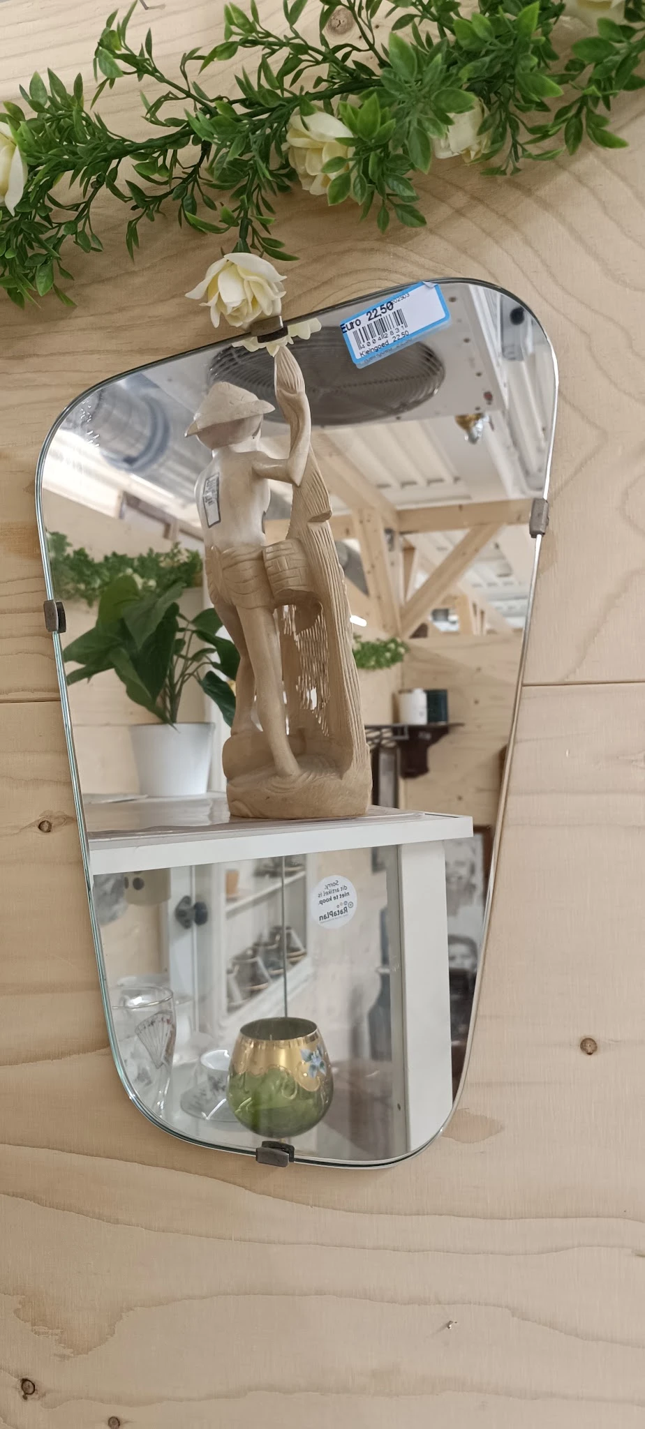 Spiegelkast met witte plant en beige tas op plank