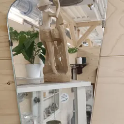 Spiegelkast met witte plant en beige tas op plank