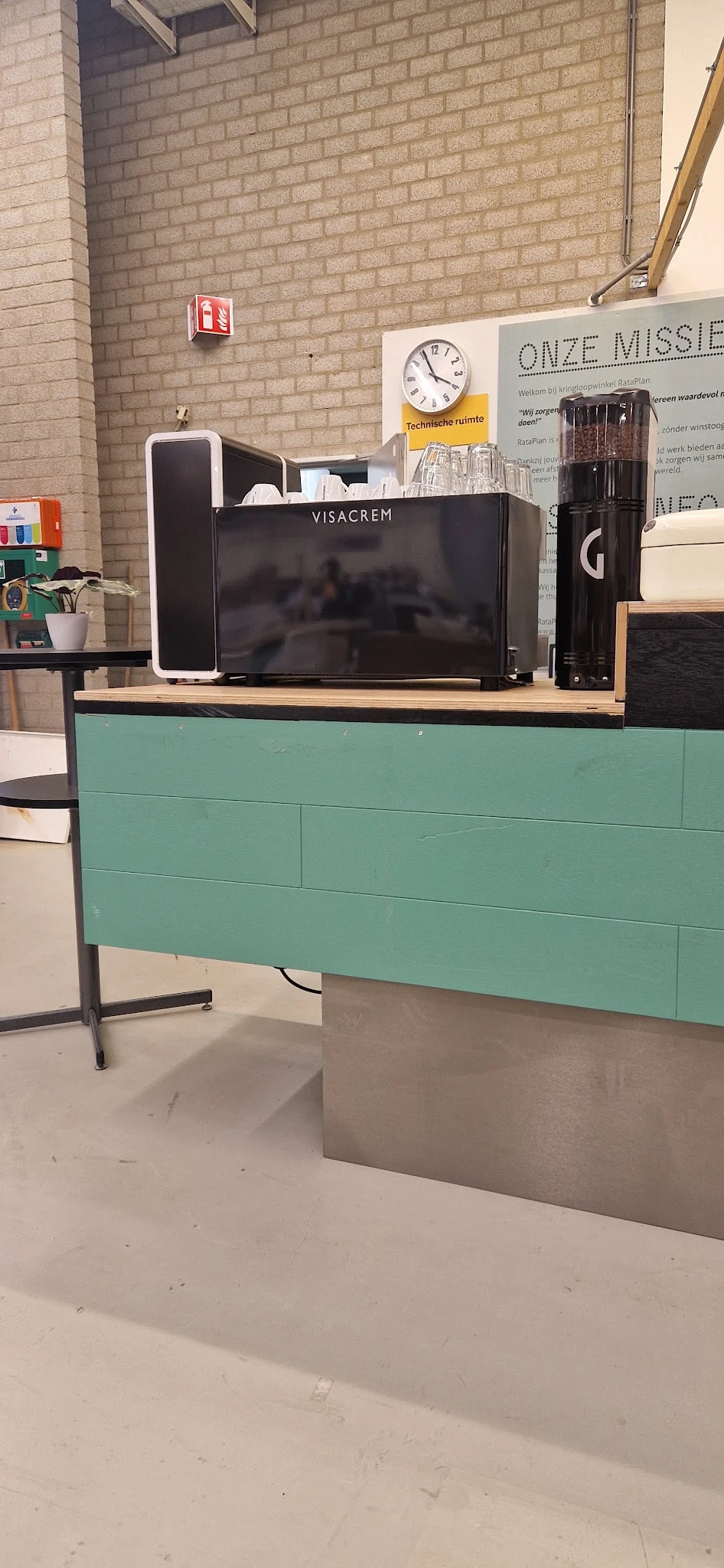 Turquoise tv-meubel met houten blad en zwarte poten, met monitor erop