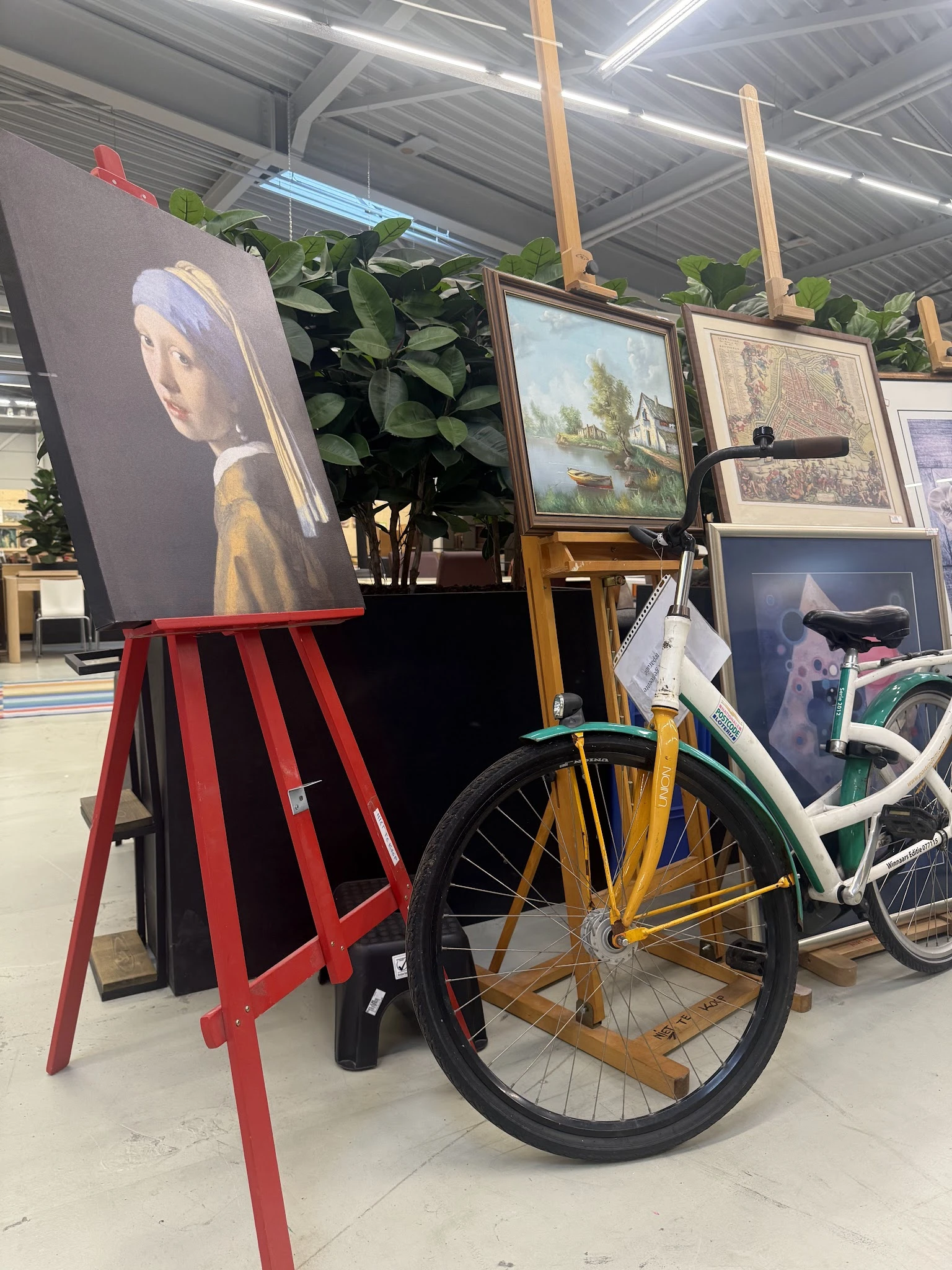 Uitgestalde tweedehands artikelen inclusief fietsen, schilderijen, kunst en decoratie