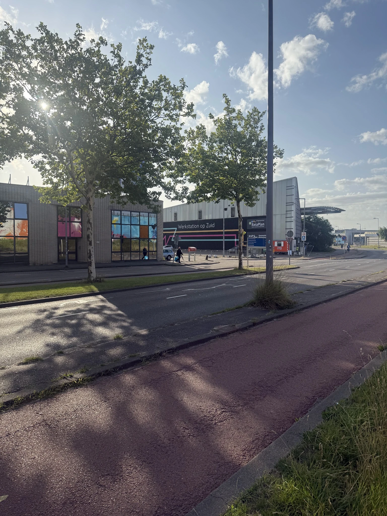 Exterieur van kringloopwinkel met moderne gevel, grote ramen en ingang aan straat met parkeerplaats