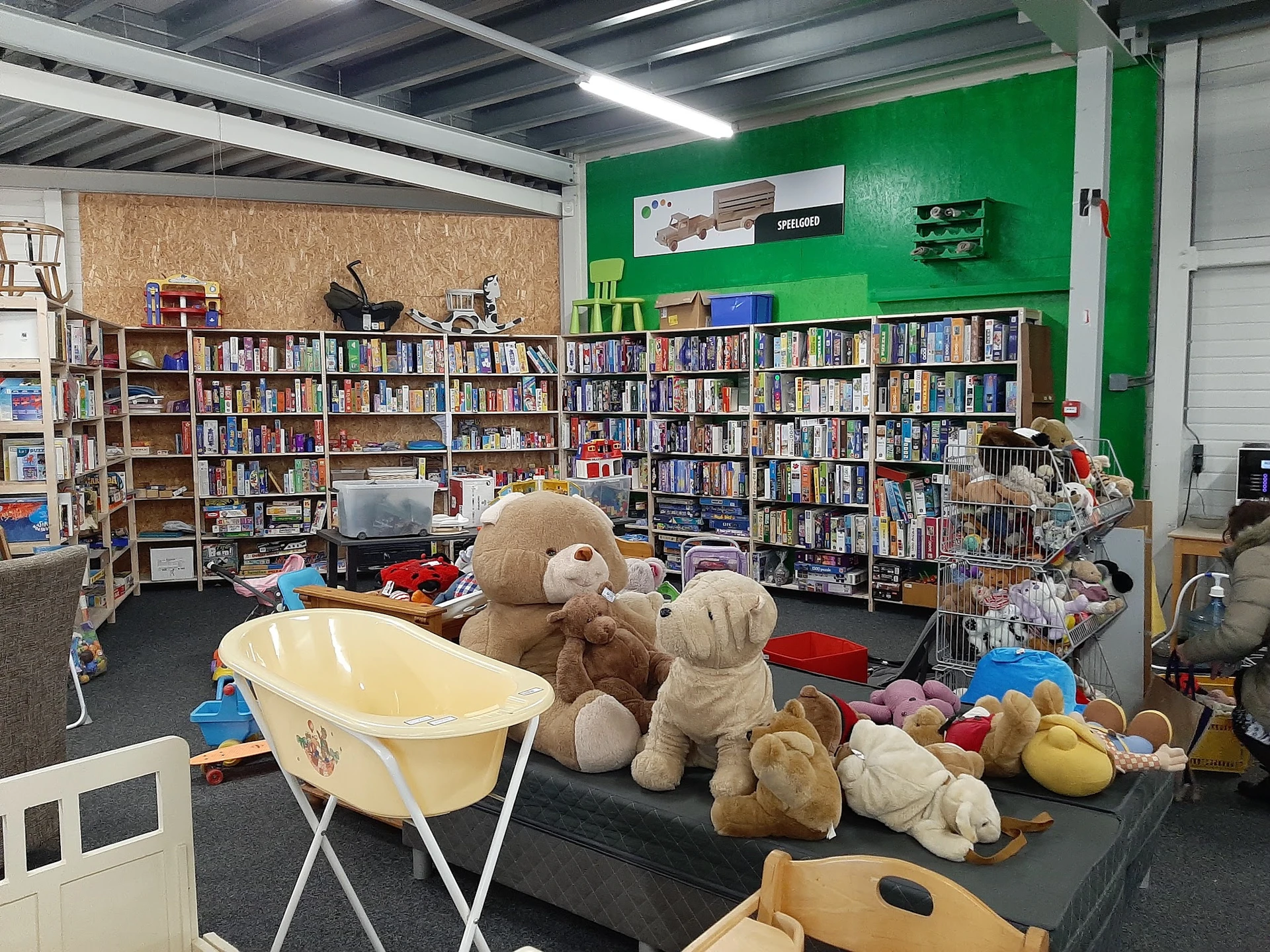 Winkelvloer met boekenrekken, speelgoedkast en knuffels op de grond