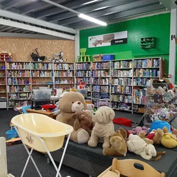 Winkelvloer met boekenrekken, speelgoedkast en knuffels op de grond