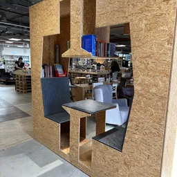 Interieur van kringloopwinkel met kurken scheidingswanden en zithoek met tafel en stoelen