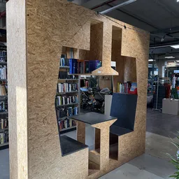 Inrichting met boeken in kasten en een zwarte tafel in een winkelruimte met een motor op de achtergrond