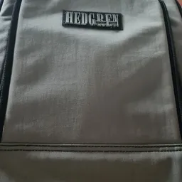Grijze stof tas of rugzak met rits en label, close-up van de voorkant