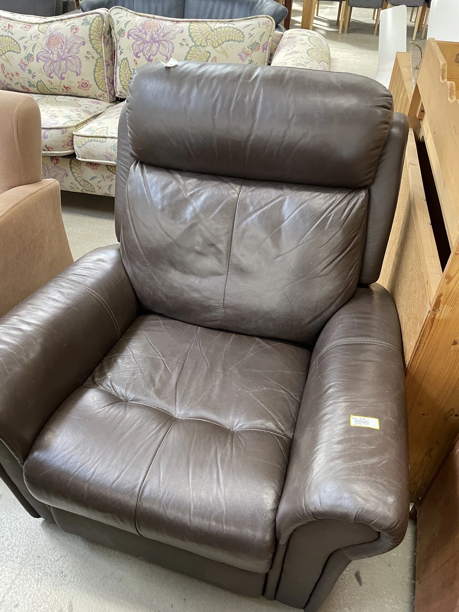 Grijze leren relaxstoel met voetsteun in showroom