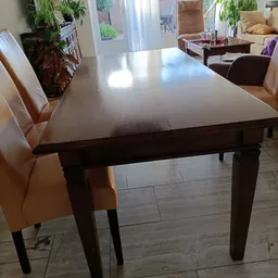 Glanzende grijze eettafel met donkerbruine houten poten en beige stoelen ernaast