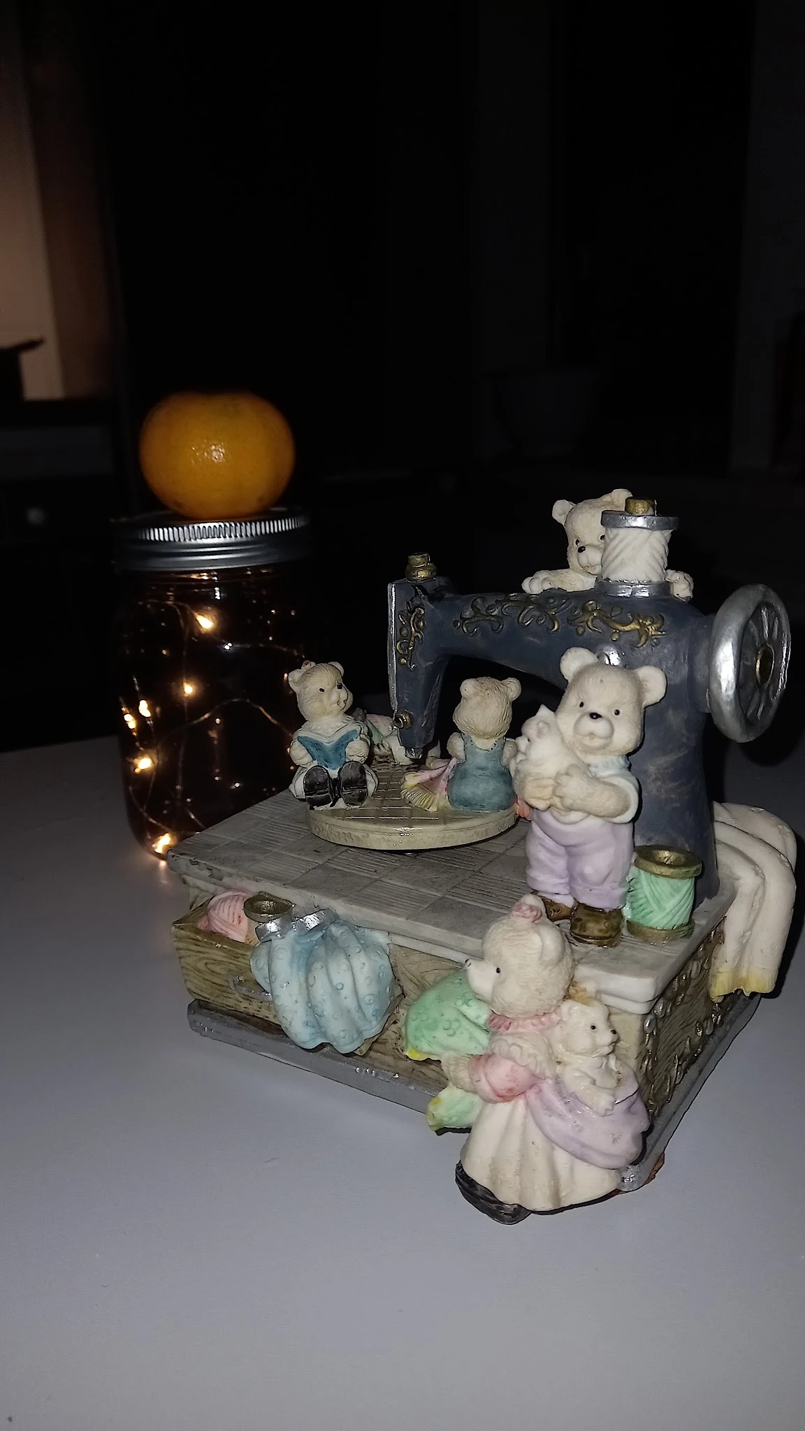 Decoratieve display met teddyberen en vintage naaitmachine op houten podium met verlichting