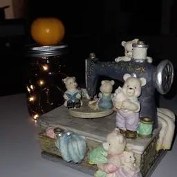 Decoratieve display met teddyberen en vintage naaitmachine op houten podium met verlichting