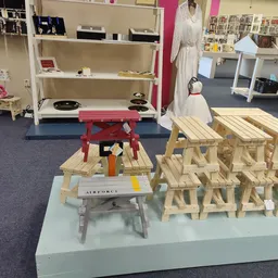 Houten meubelstukken en zelfbouwsets uitgestald op tafels in de winkel