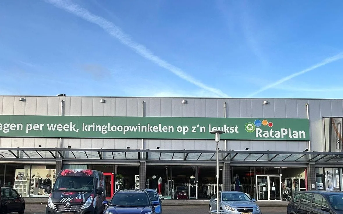 Gevel van kringloopwinkel RataPlan in Zaandam met groene luifel en winkelnaam duidelijk zichtbaar