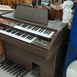 Vintage elektronisch orgel met twee manualen en pedaalbord in bruine houten behuizing