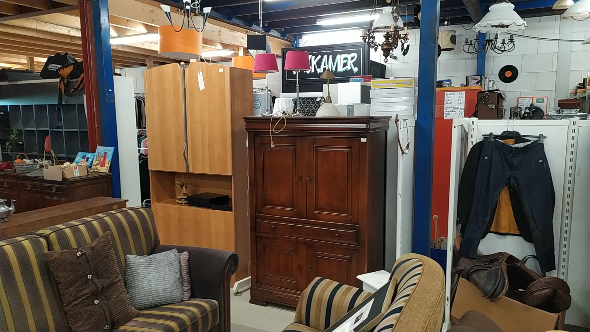 Winkelinterieur met meubels, stoelen, een houten kast en verschillende huishoudartikelen