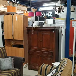 Winkelinterieur met meubels, stoelen, een houten kast en verschillende huishoudartikelen