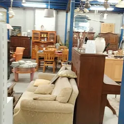 Winkelvloer met meubels: bank, houten kasten, tafels en stoelen uitgestald
