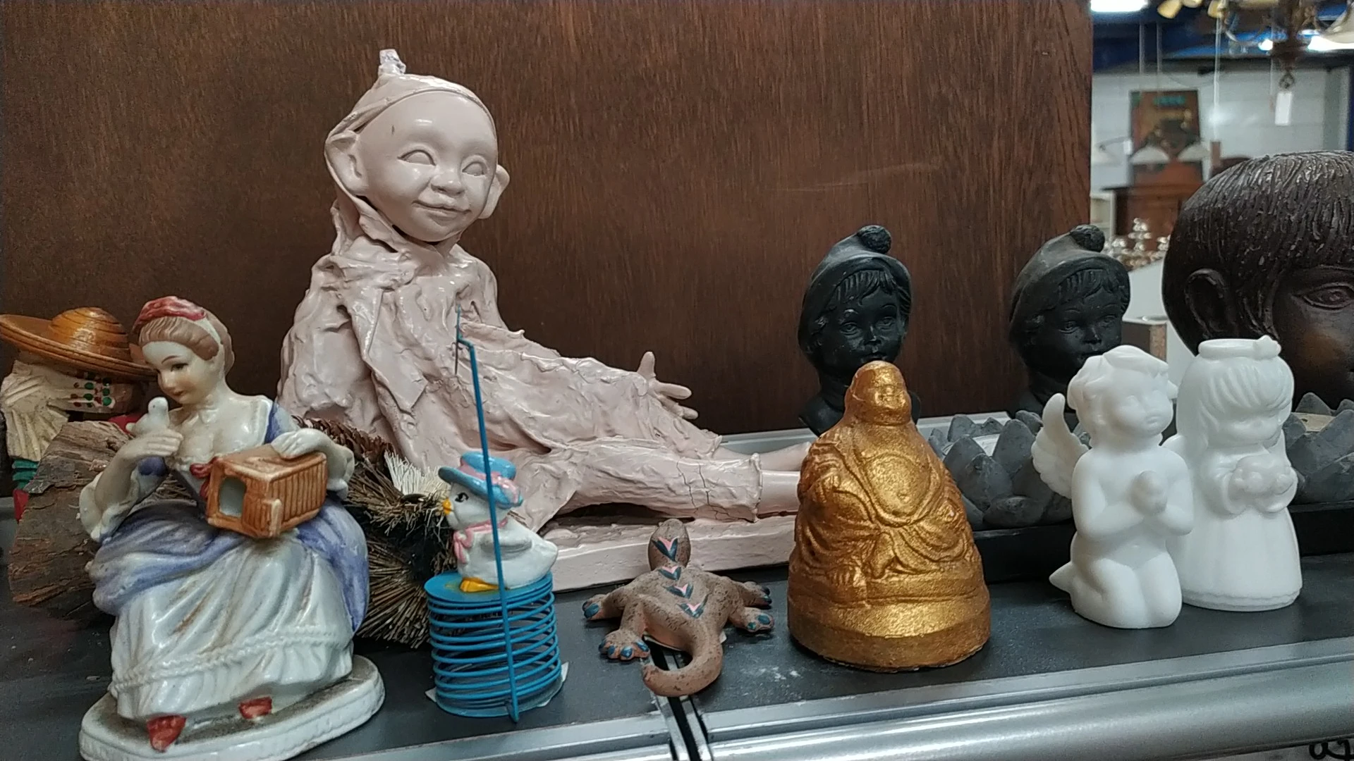 Verzameling decoratieve beelden en figuren uit verschillende materialen en kleuren op een donkere plank