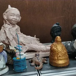 Verzameling decoratieve beelden en figuren uit verschillende materialen en kleuren op een donkere plank