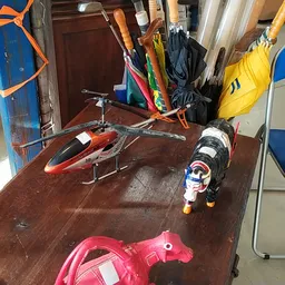 Tweedehands speelgoedhelikopters en vliegtuigmodellen op een houten tafel in de winkel