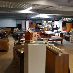 Overzicht van de winkelvloer met meubels, stellingen en diverse tweedehands artikelen