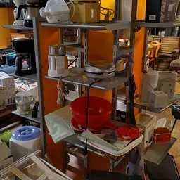 Overzicht van de winkelruimte met stellingen vol huishoudartikelen, serviesgoed en diverse voorwerpen
