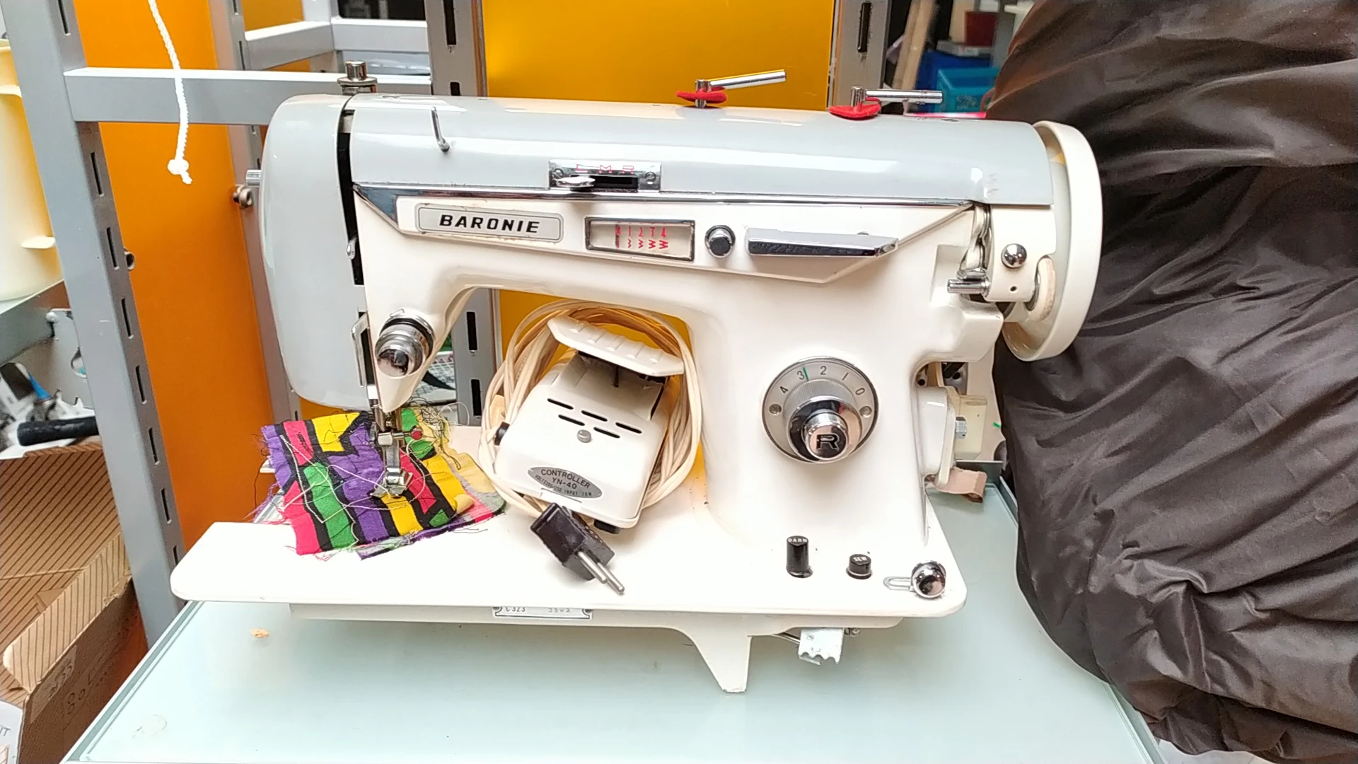 Witte Baronie naaimachine van dichtbij met gekleurde stoffen ernaast
