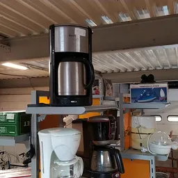 Koffiezetapparaten op een oranje werkblad in een werkplaats of opslagruimte