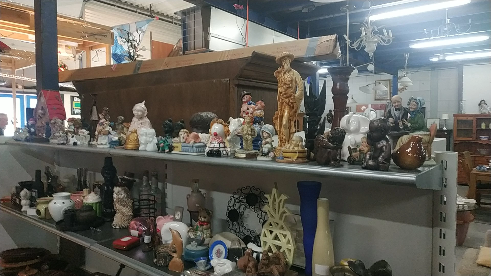 Twee stellingkasten met diverse decoratieve artikelen, beelden, vazen en verzamelobjecten.