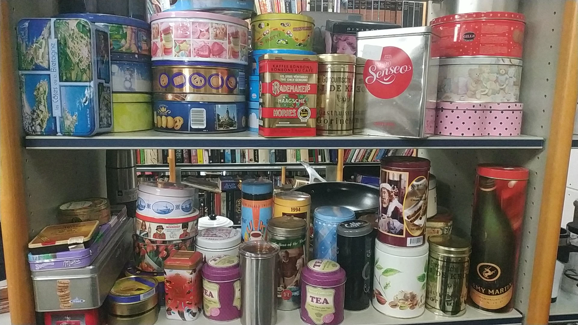 Twee schappen vol met diverse blikken, tins en dozen, waaronder thee, koffie en andere voorraden