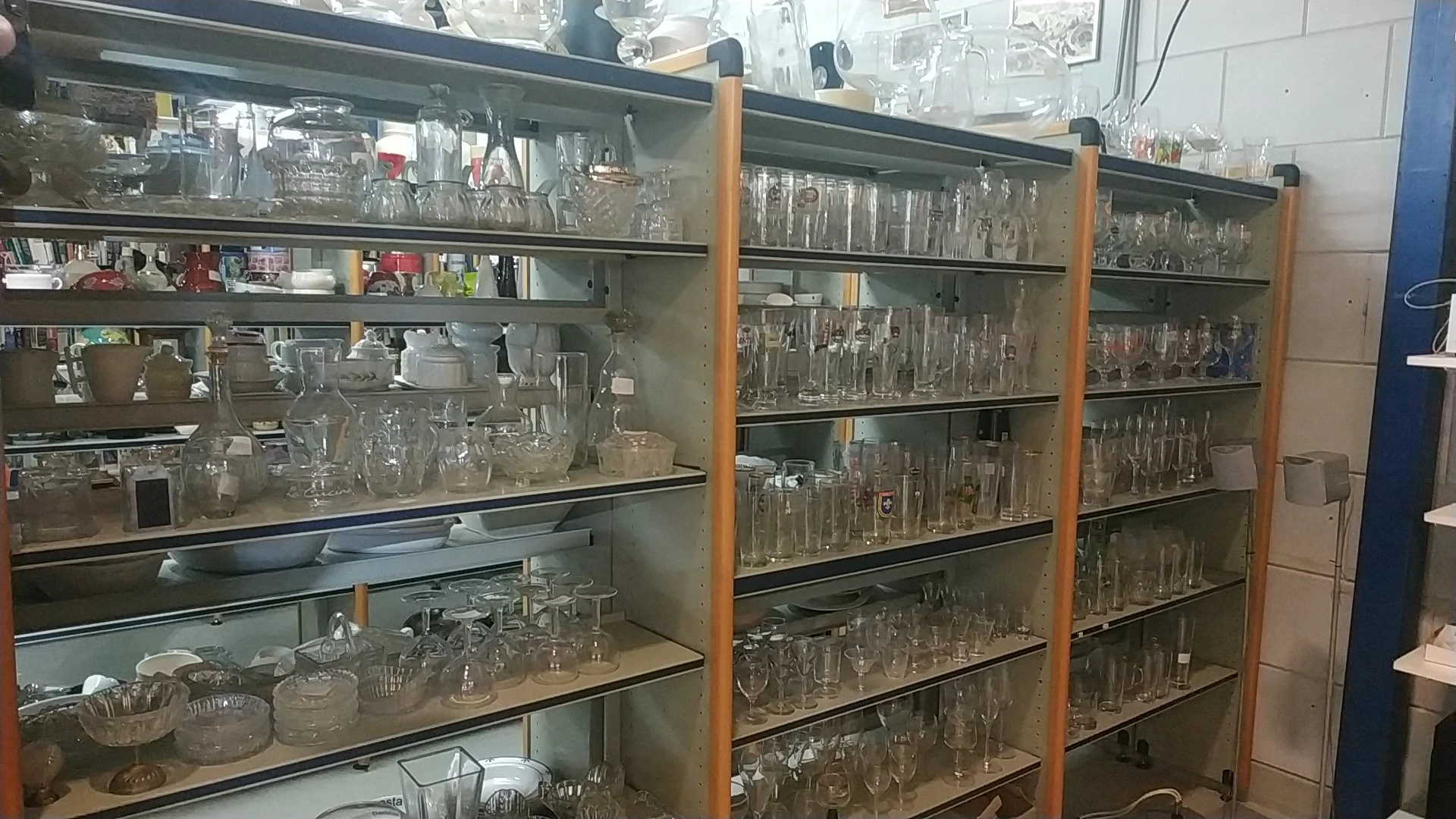 Glazen kasten vol met diverse glazen bekers, glazen en vaatwerk in verschillende maten en stijlen