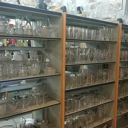 Glazen kasten vol met diverse glazen bekers, glazen en vaatwerk in verschillende maten en stijlen