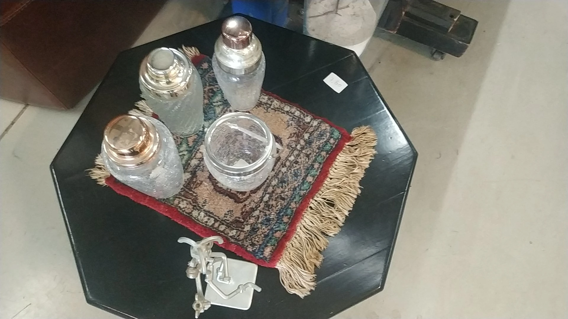 Glazen potten en potjes op een decoratief kleedje op een zwarte tafel
