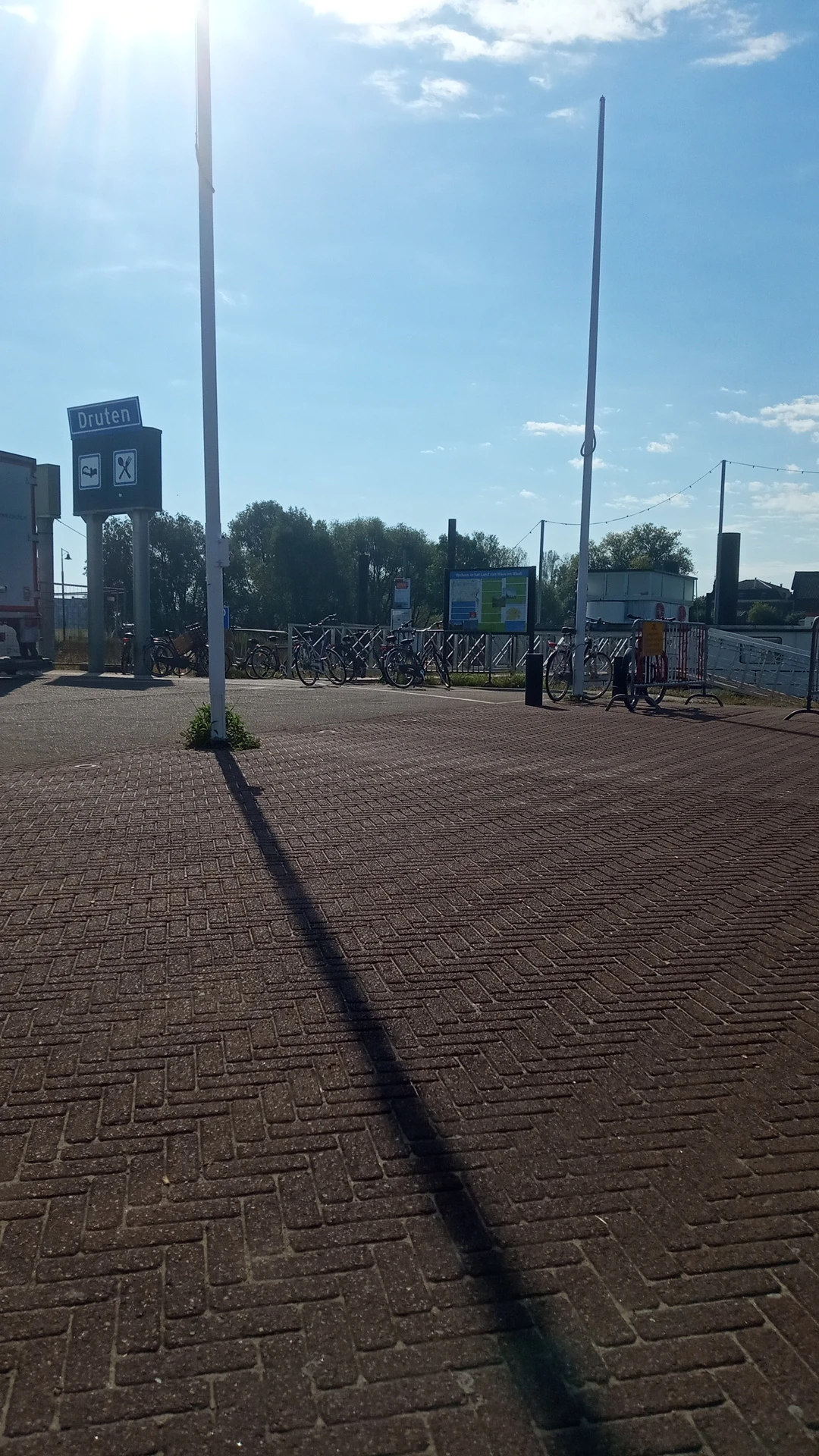 Parkeerterrein met fietsenstalling en ingang van kringloopwinkel