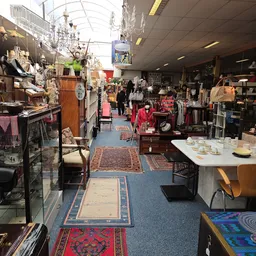 Winkelvloer van kringloopwinkel met diverse meubels, kleding, servies en huishoudelijke artikelen uitgestald